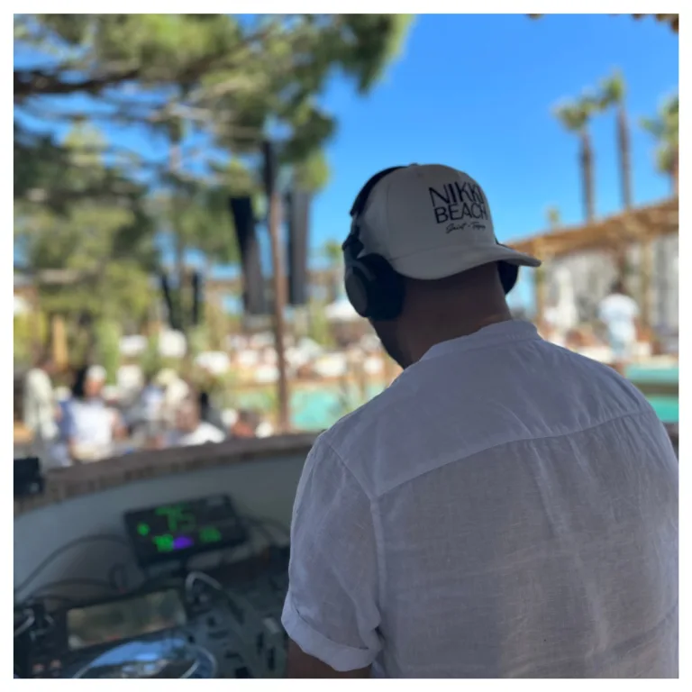 Le DJ de MGK Events de dos, aux platines d'une soirée au bord d'une piscine